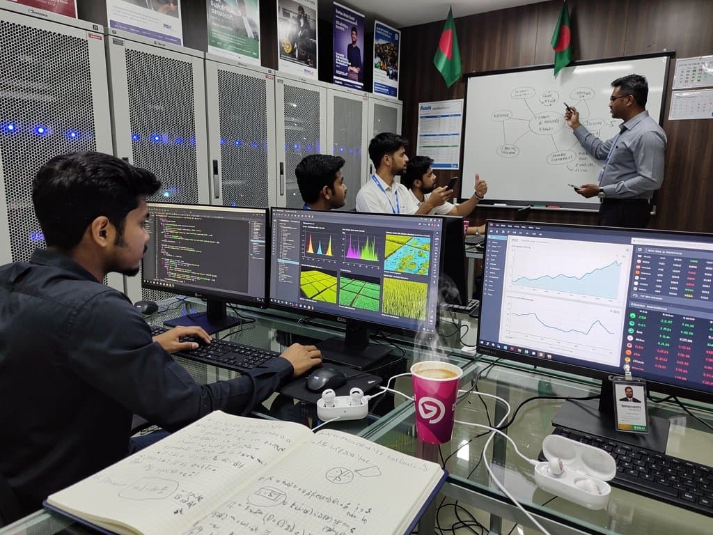 Jessore tech lab with AI screens showing code, agriculture AI charts, fintech remittance flows, and crypto prices overlooking fields